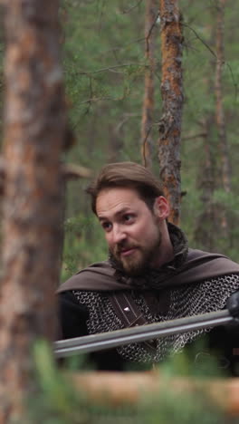 bearded man in armor with cape teaches children sword fight at military camp slow motion. soldiers training at medieval period. reconstruction role play