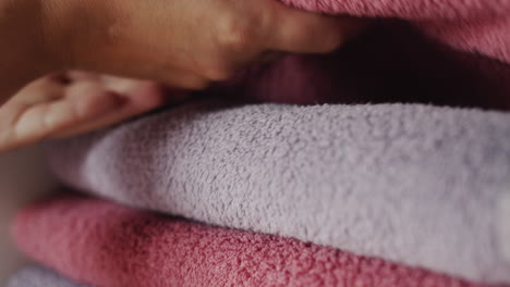 woman taking a towel from a shelf