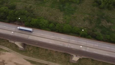 toma aérea de arriba hacia abajo de la conducción de camiones industriales en puentes de brazo largo en argentina