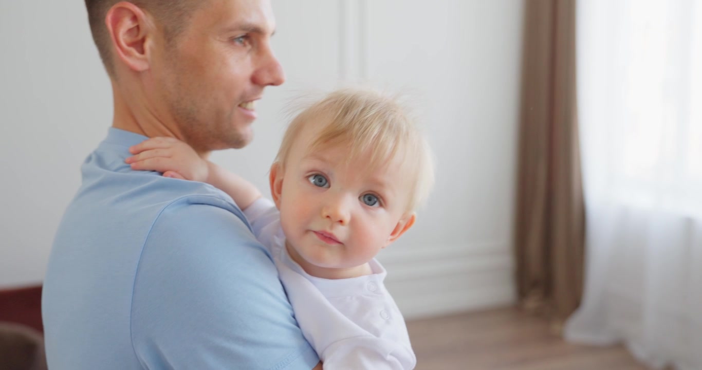 Padre felice che tiene in braccio il suo adorabile figlio neonato a casa.