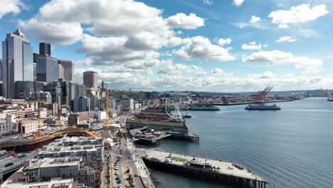 Establecimiento-De-Una-Toma-De-La-Fuente-De-Agua-De-Seattle-Sobre-La-Bahía-De-Elliott-Con-La-Gran-Rueda,-Antena-En-Un-Cielo-Azul-Nublado