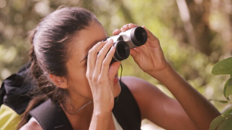 Young woman looking through binoculars