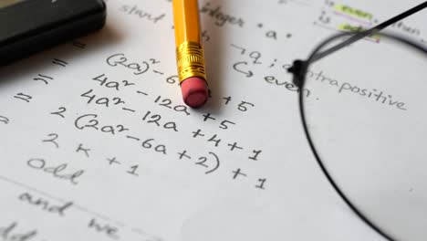 math worksheet with calculator, pencil, and glasses