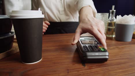 paying with credit bank card in cafe. touch-free and contactless food shopping in restaurant. nfc technology concept. buying coffee, hot drink.