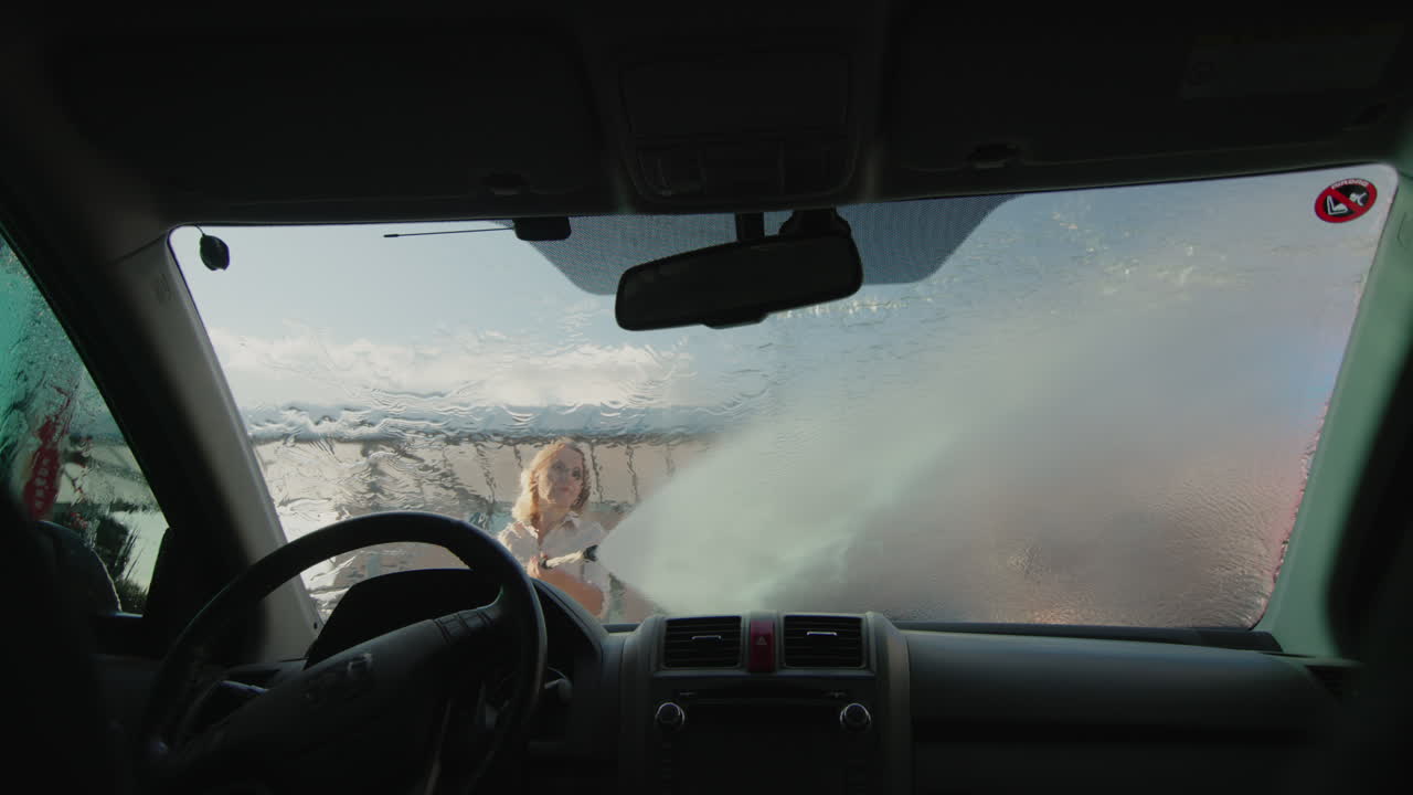 mujer de mediana edad lava un auto en una estación de autoservicio 1