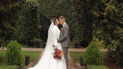 Newlyweds,-caucasian-groom-with-bride-walking,-embracing,-hugs-in-park,-wedding-couple