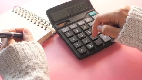 persona que utiliza una calculadora y un cuaderno