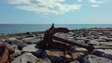 Viejo-Ancla-Oxidada-Sobre-Enormes-Rocas-En-La-Bahía-De-Povoacao,-Isla-De-San-Miguel,-Azores,-Portugal