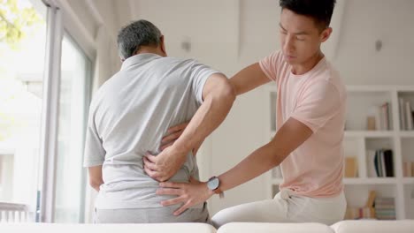 fisioterapeuta masculino diverso examinando a un paciente masculino anciano, en cámara lenta