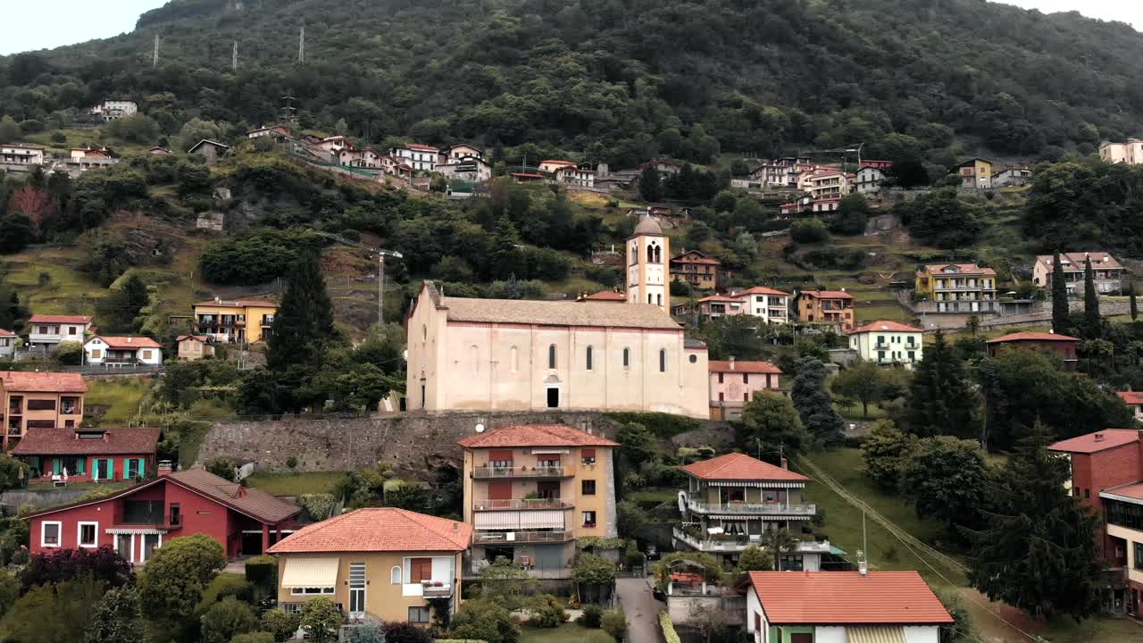 una iglesia mira sobre la costa del lago como en domaso, italia