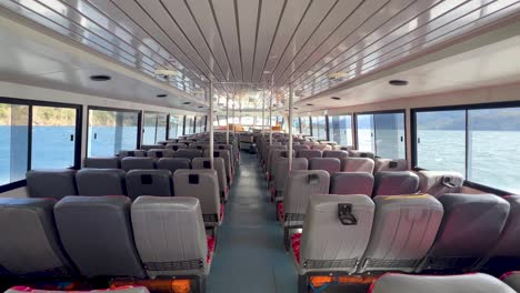 empty boat interior with seats, windows showcasing ocean view, patagonia journey vibe