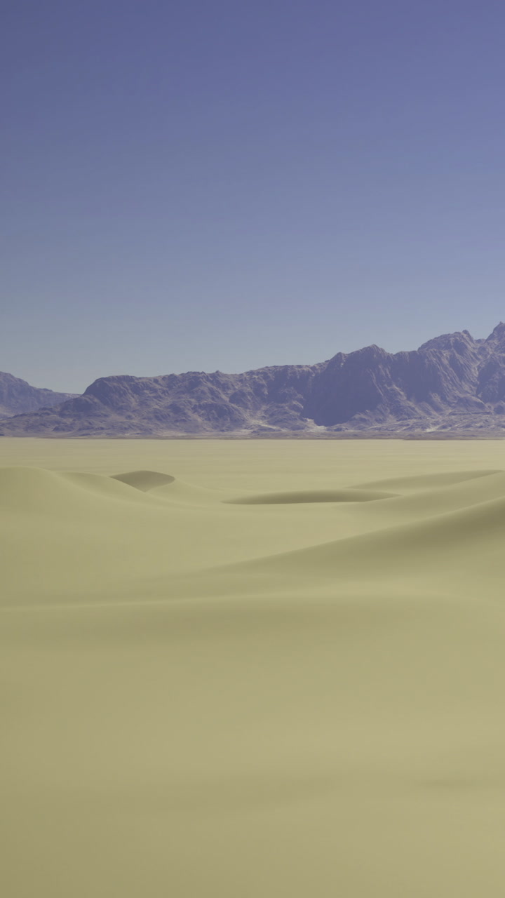 Wide view of sandy landscape with mountains under clear sky in daylight