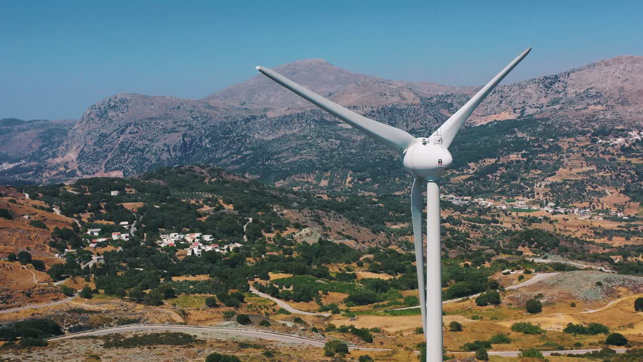 Modern wind turbines spinning gracefully in the countryside of Crete, highlighting renewable energy in harmony with nature