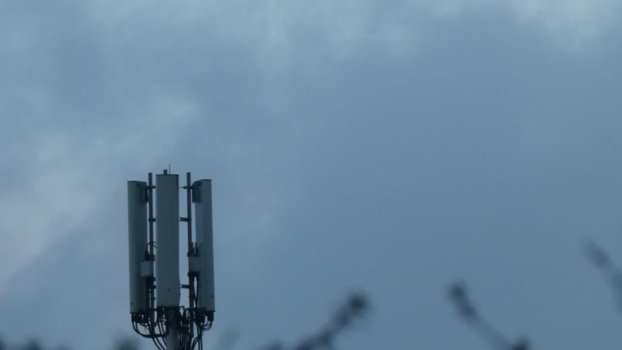 мрачное облако, проплывающая луна за вышкой сотовой телекоммуникационной передачи