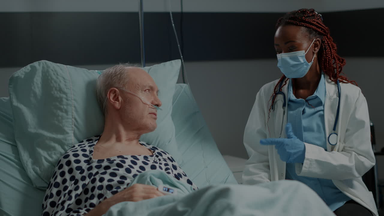 Recovering patient in hospital ward getting consultation