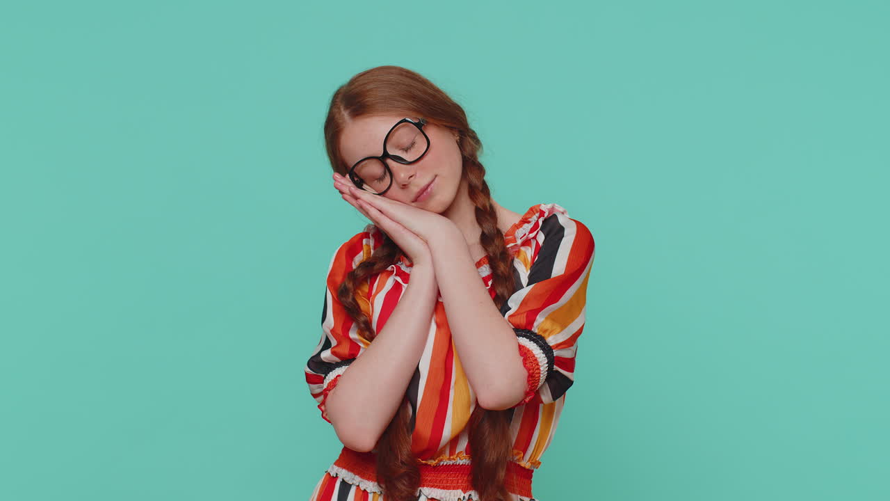 chica pelirroja cansada va a dormir acostado en sus palmas, bostezando, tomando la siesta y descansando, hora de acostarse