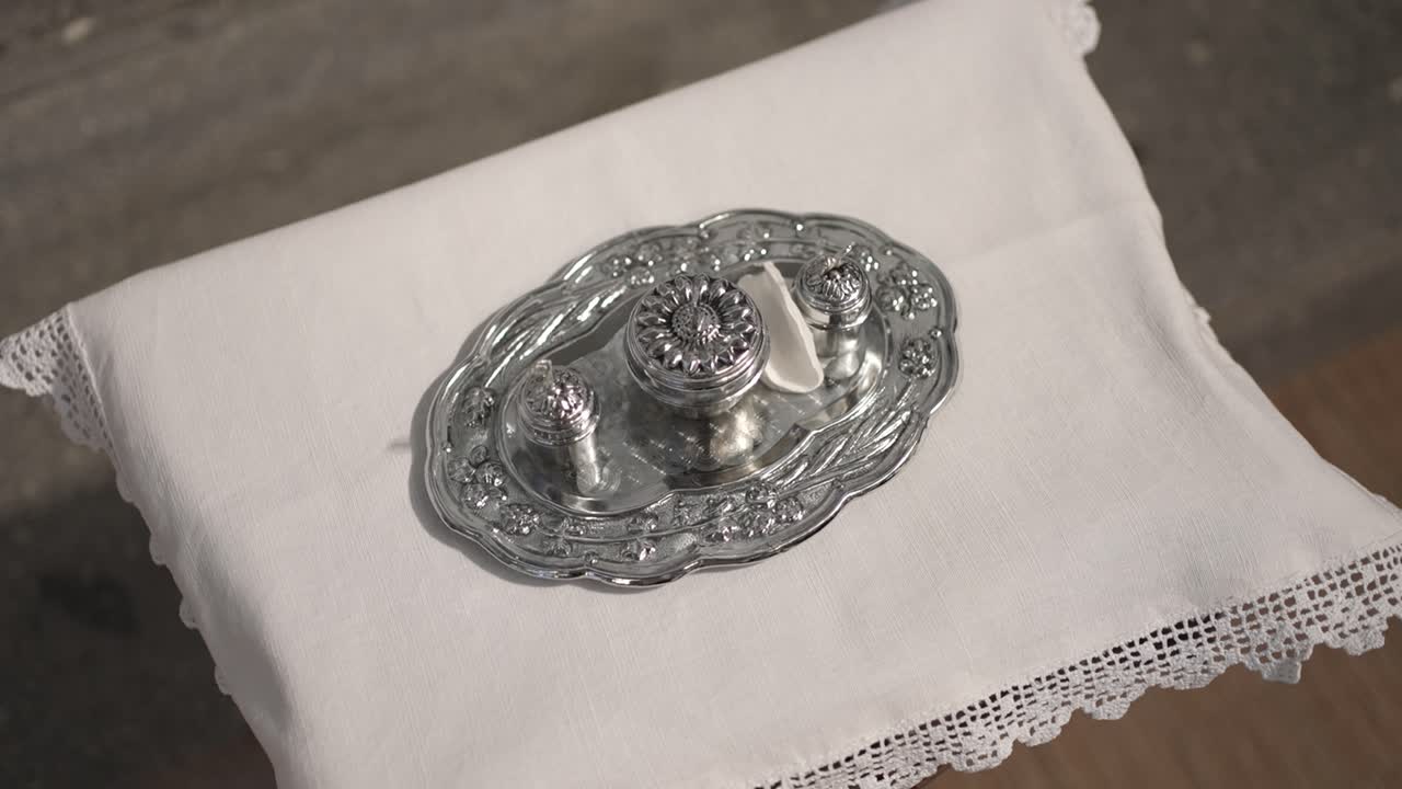 Close-up of silver cruet set used for holy oils on lace altar cloth