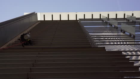 a window washer swings back and forth on his rope