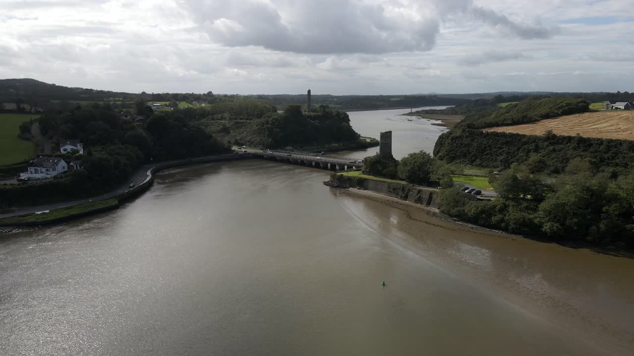 Veduta aerea con drone di un estuario fluviale con un ponte trafficato e rovine di un castello