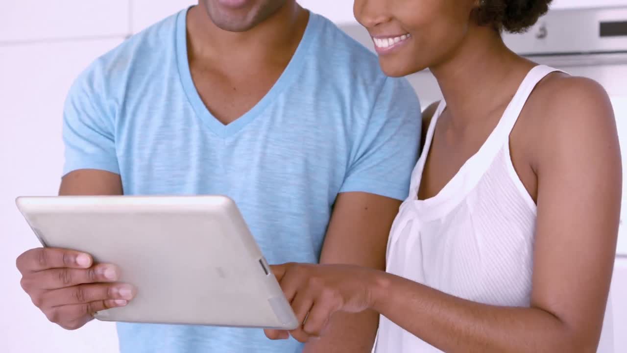 Smiling couple using tablet together