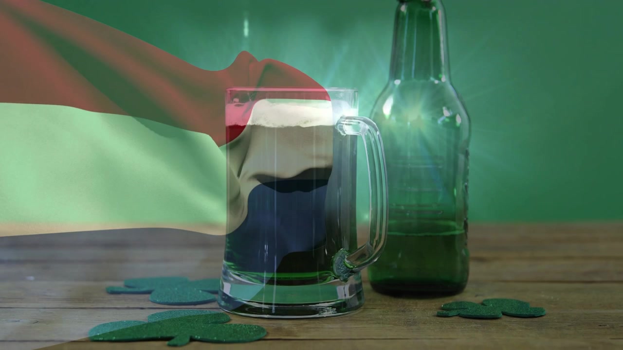 Glass beer mug being covered and uncovered as flag entering from left, revealing shamrocks