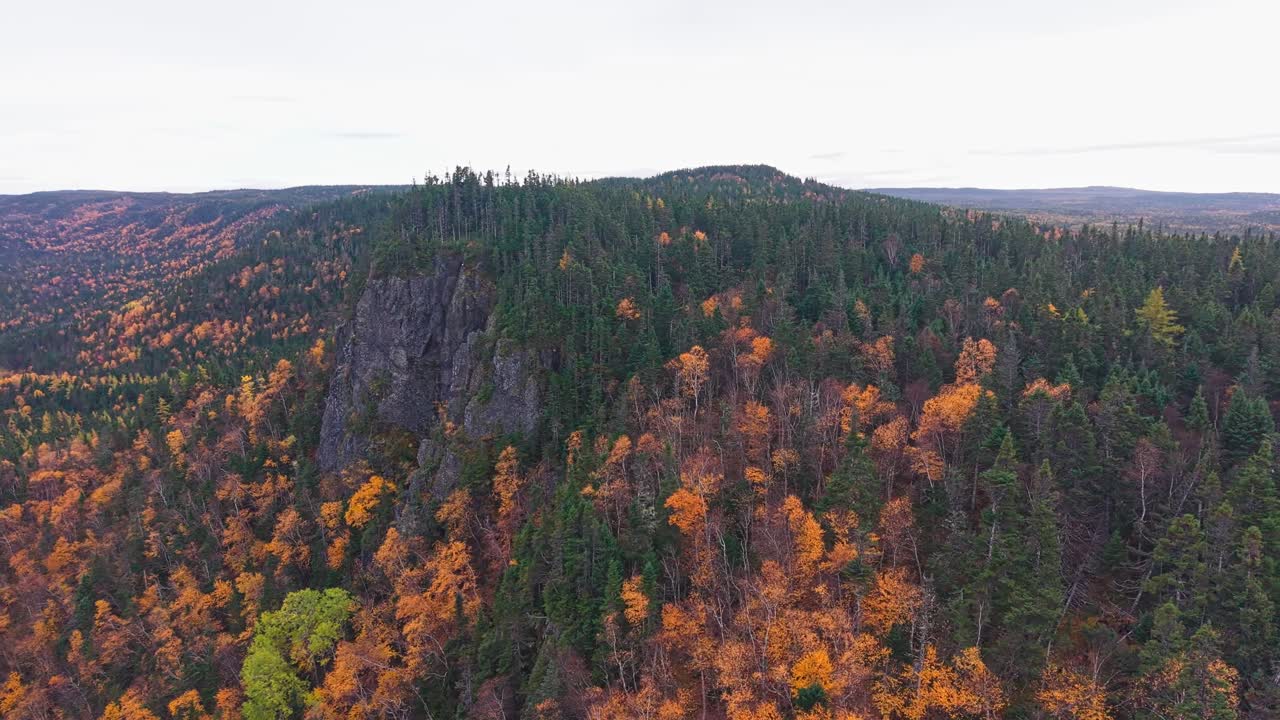 Drone footage shows rugged cliffs and rolling ridges with steep escarpments