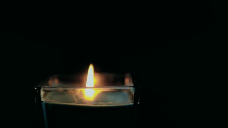 soplando una vela, humo en cámara lenta, contra un fondo negro