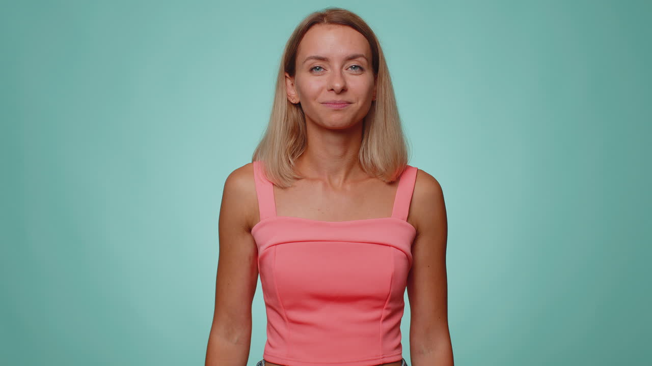 Serious blonde woman giving salute listening to order as if soldier, following discipline, obeying