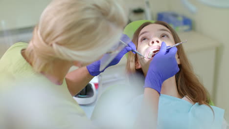 dentist examining patient teeth in medical gloves