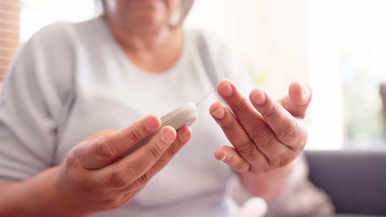 Senior woman checking blood sugar level using glucometer at home