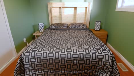 a slow tilt up showcasing a wooden accented green bedroom inside a family home