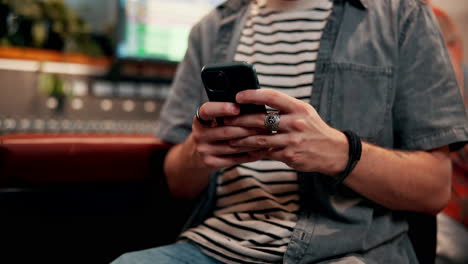 man using phone in recording studio