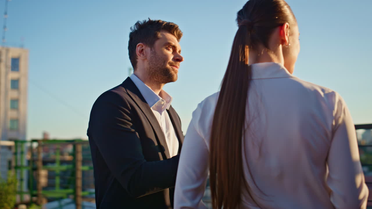 Friendly couple talking rooftop with beer looking at sunset closeup