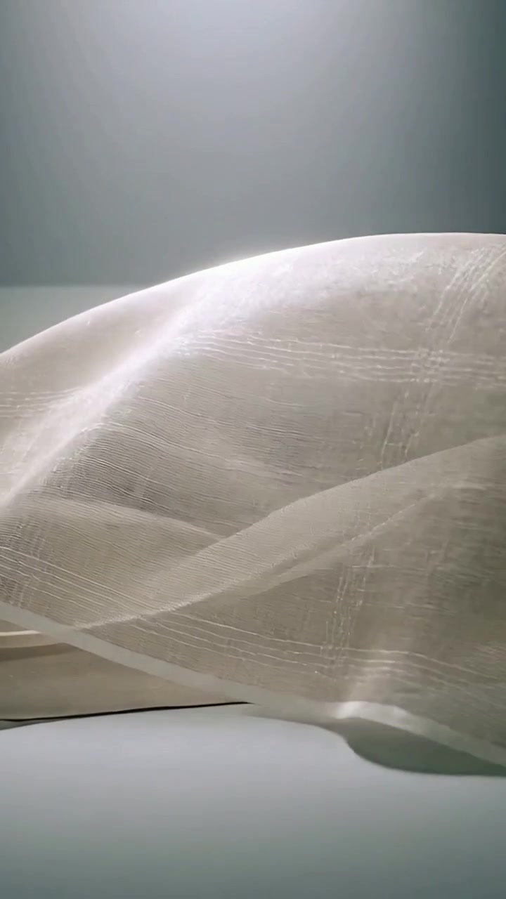 Vertical video: Billowing backlit sheer curtain forming ripples at windowsill driven by breeze