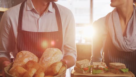 waiter and waitress holding buns and sandwiches