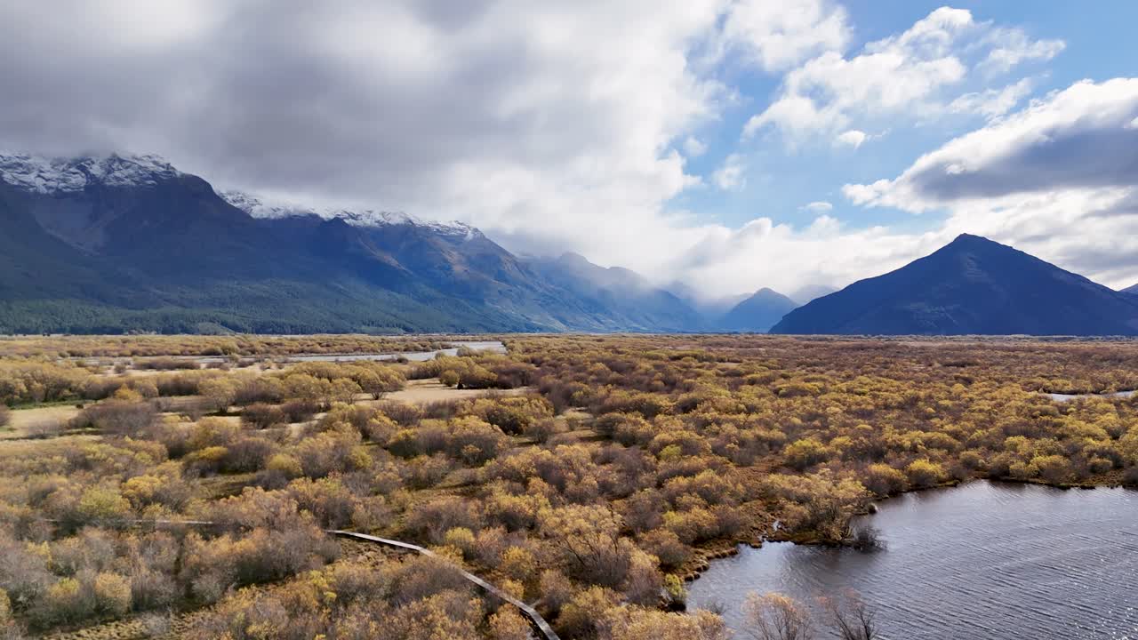A serene view of Glenorchy's mountains and river under dynamic clouds and sunlight, captured in a 13-second video
