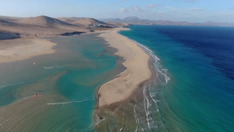 la barca beach, fuerteventura: aerial view traveling in on the beautiful beach people practicing kitsurfing