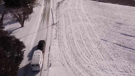 Remolque-De-Caballo-De-Remolque-De-Vehículo-En-Carretera-Rural-Helada,-Toma-Aérea-De-Drones