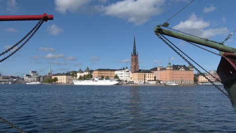 Vista-General-Del-Casco-Antiguo-De-Estocolmo,-Incluidos-Algunos-Barcos,-El-Puerto-Y-La-Torre-De-La-Iglesia-De-Riddarholmen