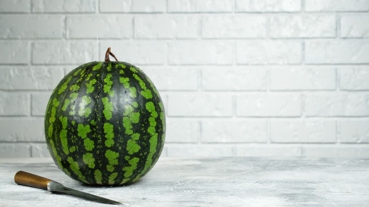 una sandía entera goteando agua.