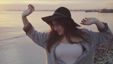 mujer disfrutando de la puesta de sol junto al agua
