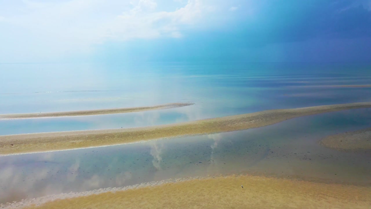 Cape Cod lightning storm coastline seen from above, with storm clouds forming over dunes and tidal pools during low tide, blending the calm beauty of sand flats with the power of incoming weather.