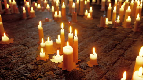 many lit candles on a stone floor