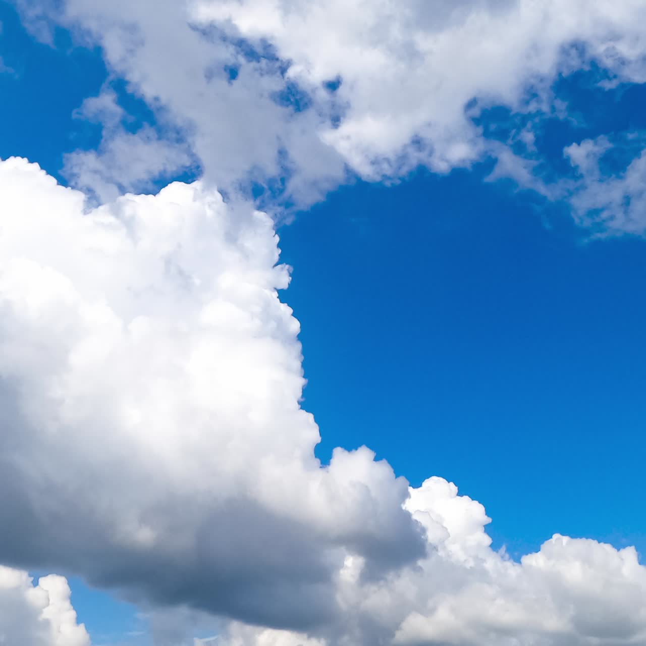 Moving forward among the amazing cumulus clouds. White clouds in the bright sunlight on summer day. Timelapse