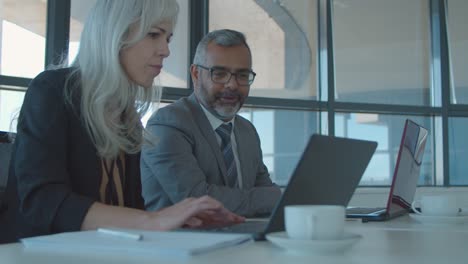 hombre de negocios y mujer sentados juntos en la computadora portátil