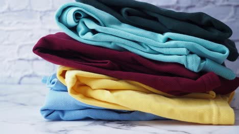 una pila de camisetas de polo de colores plegadas