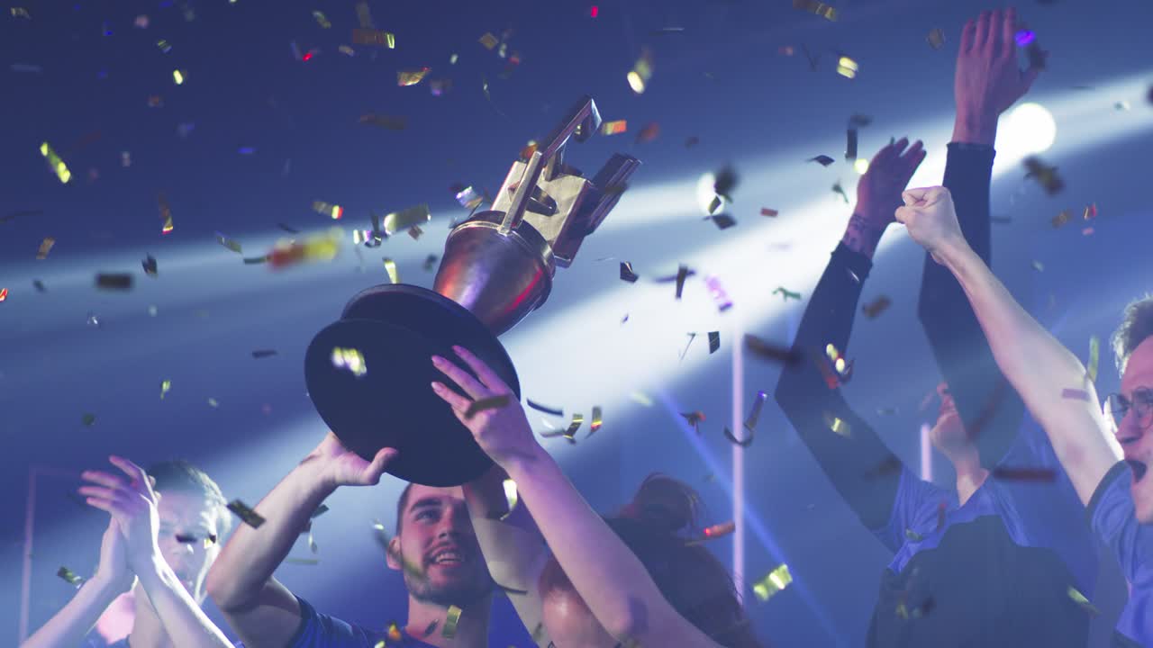 женщина-игрок поднимает трофей рядом с товарищами по команде