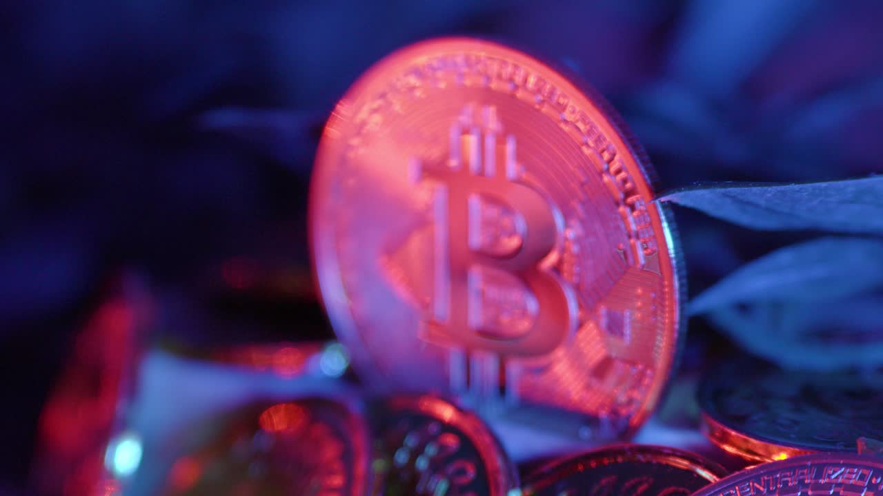 Zooming out to Bitcoins, with coins reflecting red light, symbolizing the dynamic nature of cryptocurrency and its impact on the digital financial landscape.