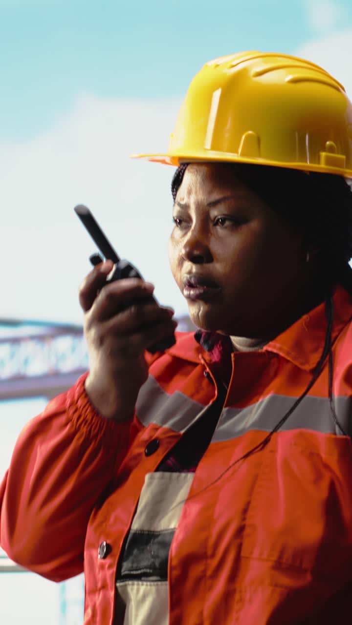 Vertical video Drilling rig specialist using walkie talkie, inspecting gear