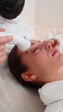 rf skin tightening around eyes for young woman by cosmetologist use beauty device in clinic session